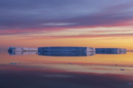 A Trio of Tabular Icebergs Reflected at Sunrise on the Solstice